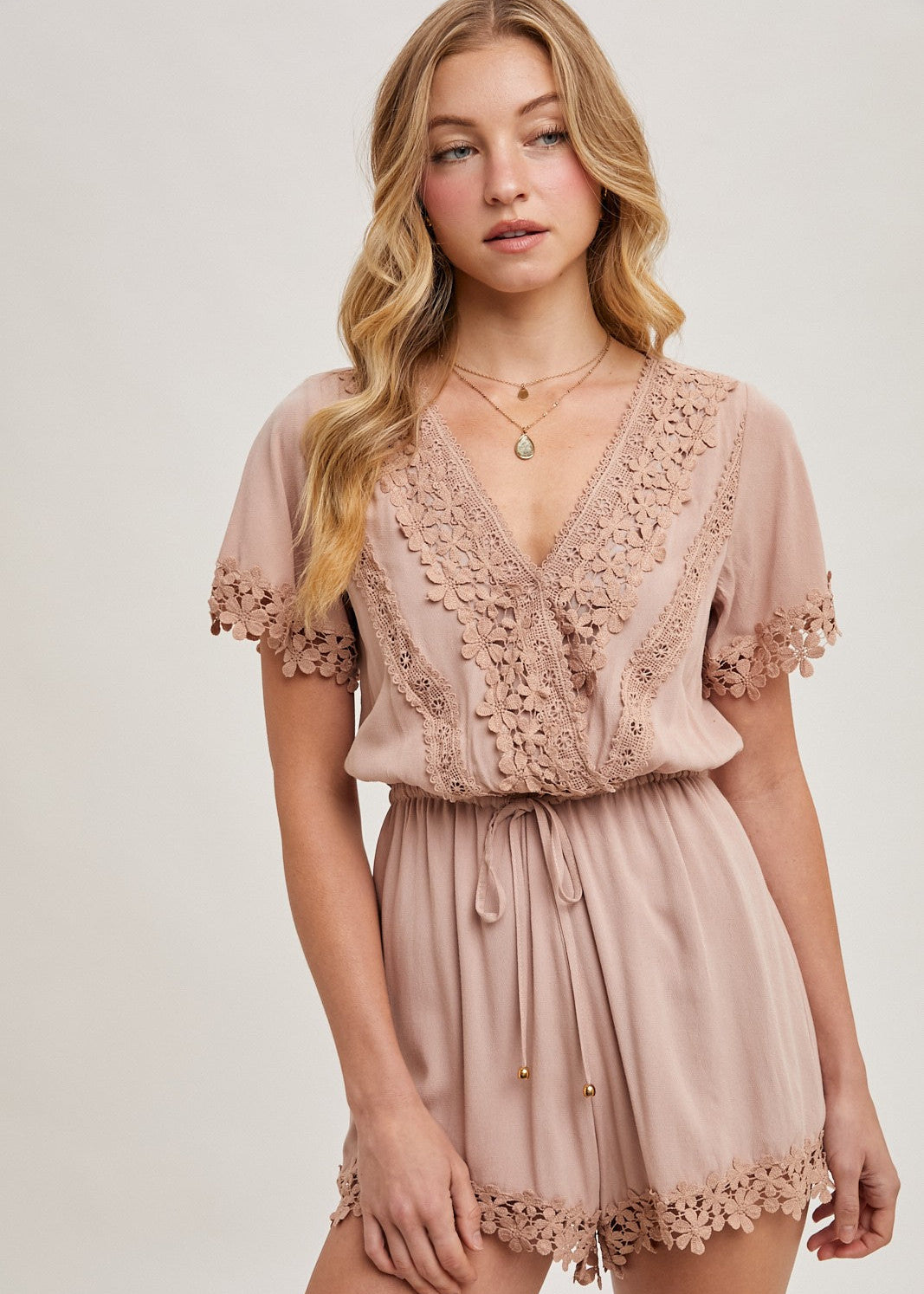The wrap floral lace trimmed drawstring romper combines elegance and comfort, featuring a flattering wrap design adorned with delicate floral lace trim. The adjustable drawstring waist ensures a perfect fit, while the soft, lightweight fabric provides ease of movement.
