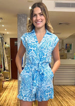 Load image into Gallery viewer, Blue and white multi print sleeveless v-neck button down romper with elastic back and self tie belt and side pockets.&nbsp;
