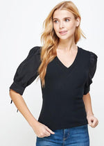 Load image into Gallery viewer, Black poplin sleeve knit top. This style features bodice in ribbed knit, a classic V neckline, and &amp; poplin short sleeves with cuff and tie detail.
