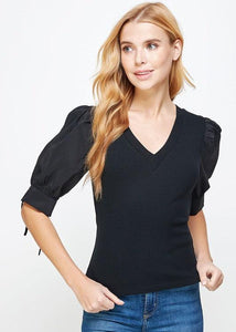 Black poplin sleeve knit top. This style features bodice in ribbed knit, a classic V neckline, and & poplin short sleeves with cuff and tie detail.