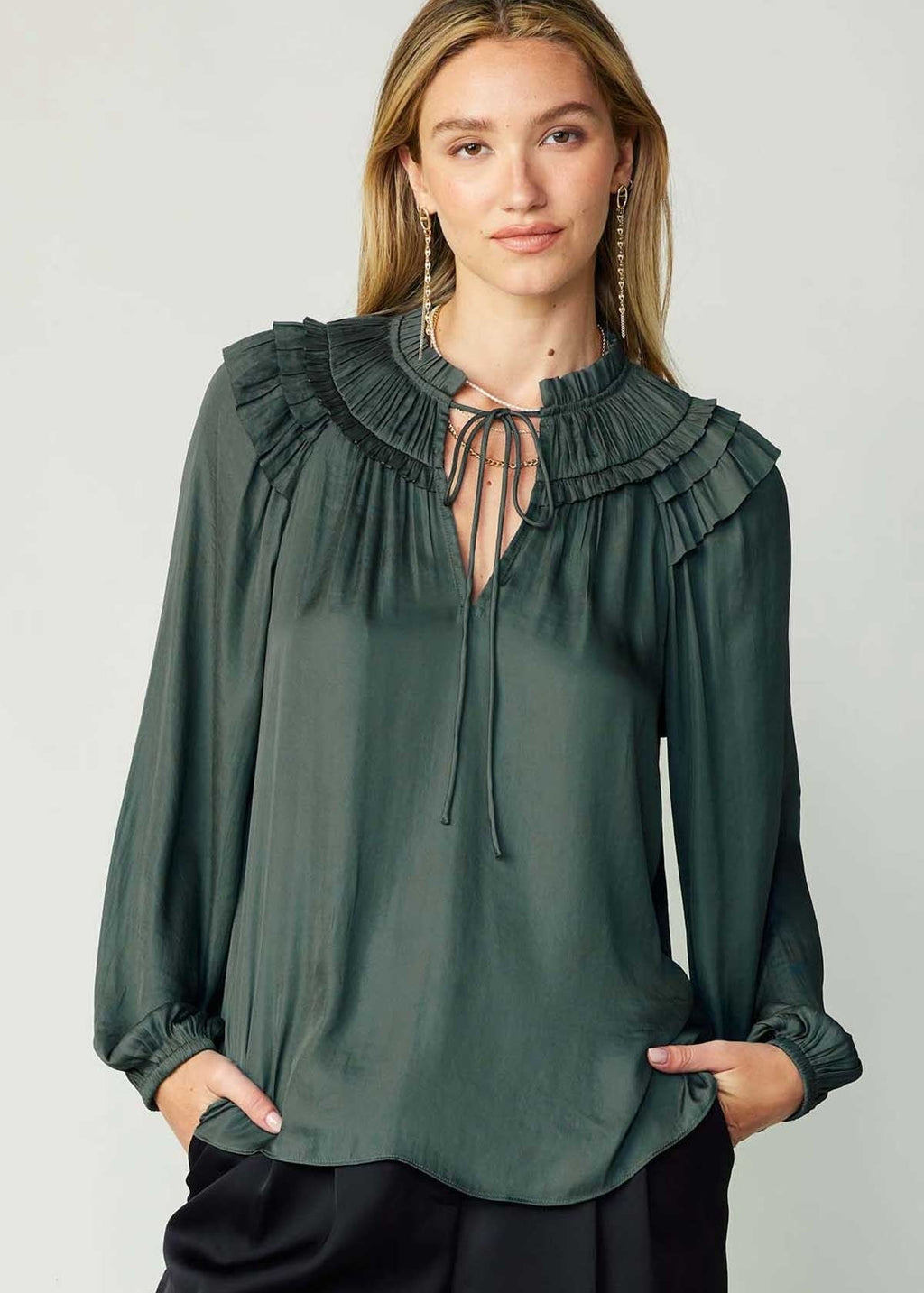 Forrest green long sleeve split neck blouse with ruffled detail on shoulder