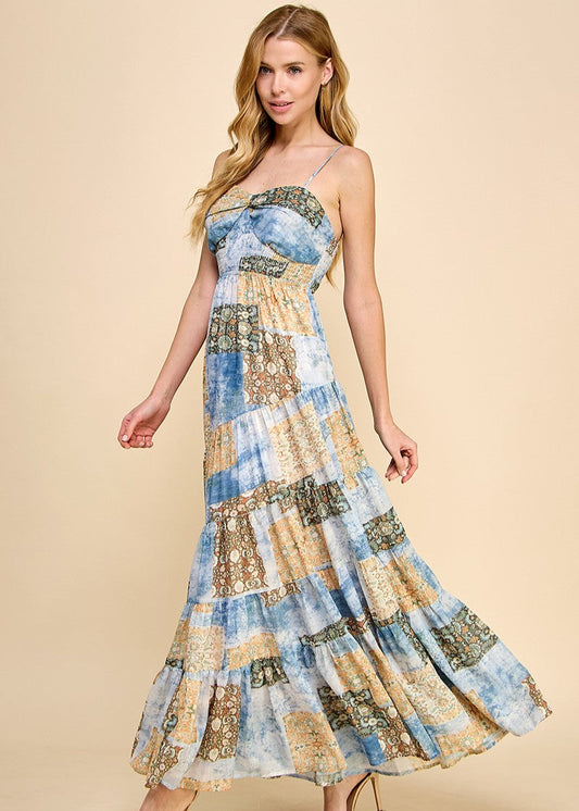 Asymmetrical tiered maxi dress with an abstract print. Featuring a smocked top and adjustable spaghetti straps.