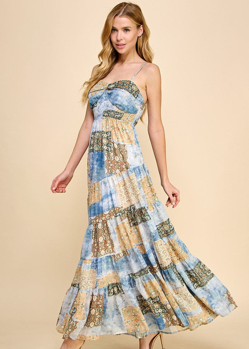Asymmetrical tiered maxi dress with an abstract print. Featuring a smocked top and adjustable spaghetti straps.