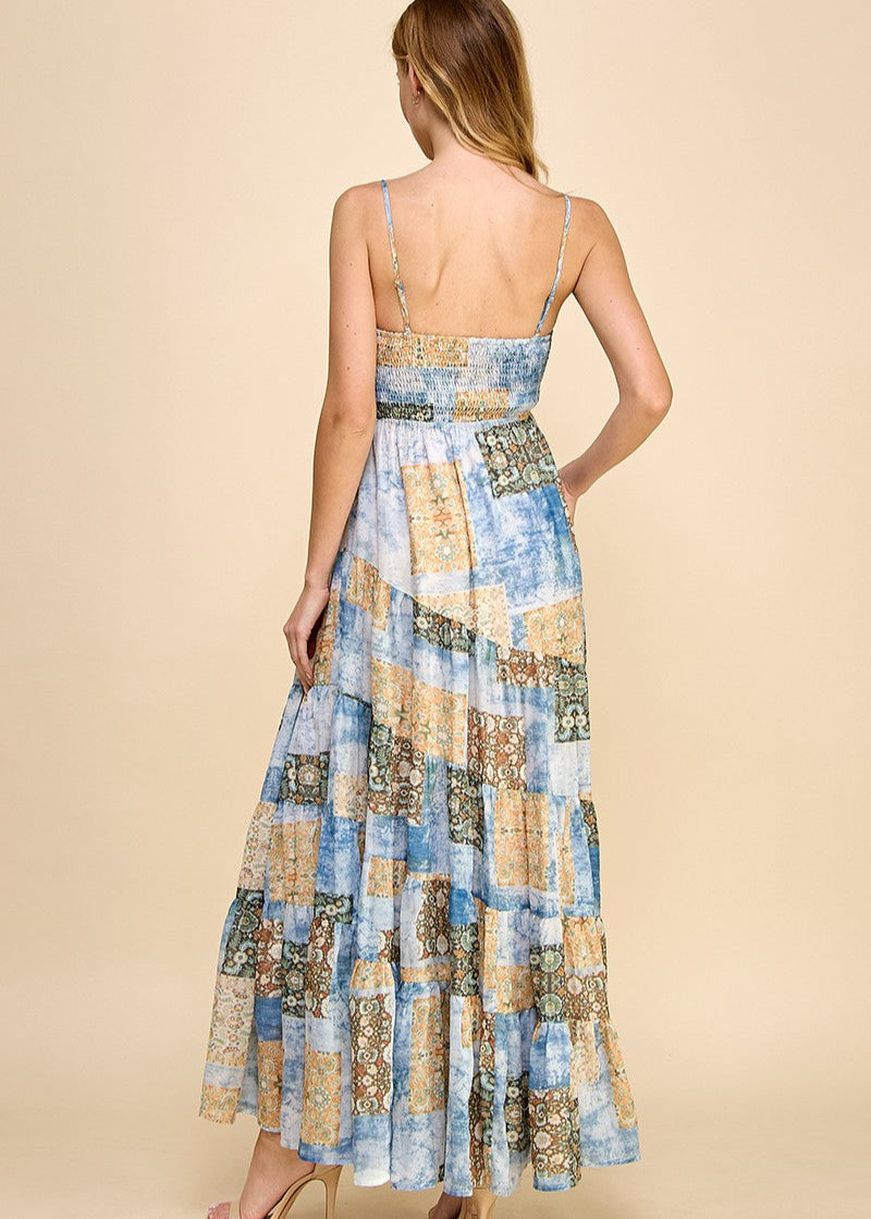 Asymmetrical tiered maxi dress with an abstract print. Featuring a smocked top and adjustable spaghetti straps.