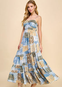 Asymmetrical tiered maxi dress with an abstract print. Featuring a smocked top and adjustable spaghetti straps.