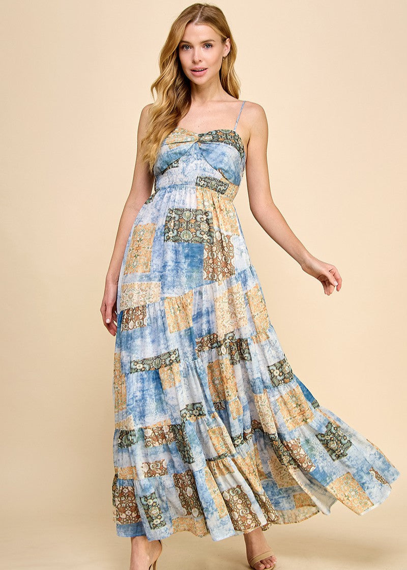 Asymmetrical tiered maxi dress with an abstract print. Featuring a smocked top and adjustable spaghetti straps.
