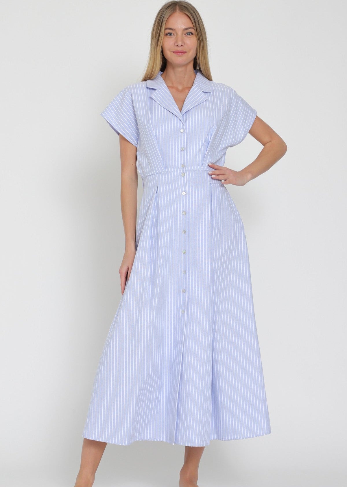 Woman wearing a blue and white striped dress on a plain background