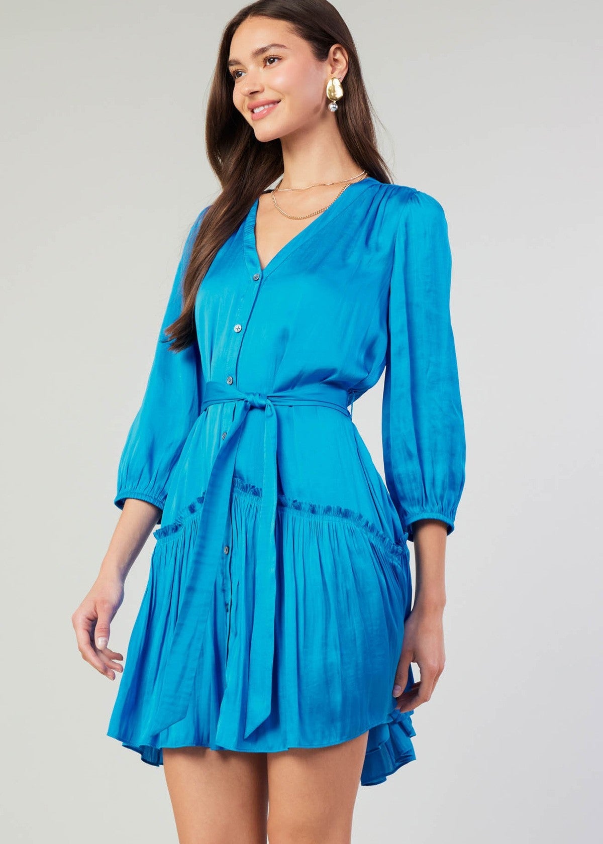 Blue v-neck 3/4 sleeve short button down dress with ruffled detail on skirt.