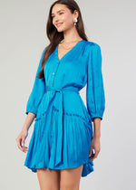 Load image into Gallery viewer, Blue v-neck 3/4 sleeve short button down dress with ruffled detail on skirt.
