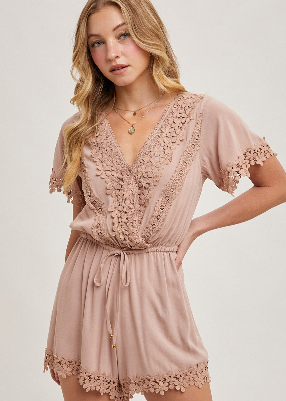 The wrap floral lace trimmed drawstring romper combines elegance and comfort, featuring a flattering wrap design adorned with delicate floral lace trim. The adjustable drawstring waist ensures a perfect fit, while the soft, lightweight fabric provides ease of movement.