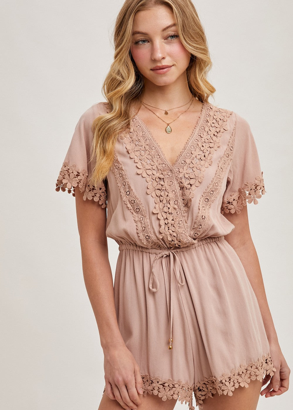The wrap floral lace trimmed drawstring romper combines elegance and comfort, featuring a flattering wrap design adorned with delicate floral lace trim. The adjustable drawstring waist ensures a perfect fit, while the soft, lightweight fabric provides ease of movement.