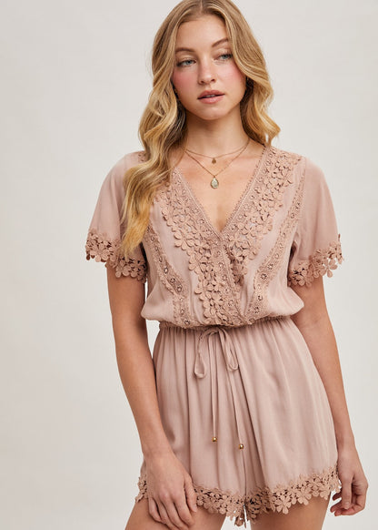 The wrap floral lace trimmed drawstring romper combines elegance and comfort, featuring a flattering wrap design adorned with delicate floral lace trim. The adjustable drawstring waist ensures a perfect fit, while the soft, lightweight fabric provides ease of movement.