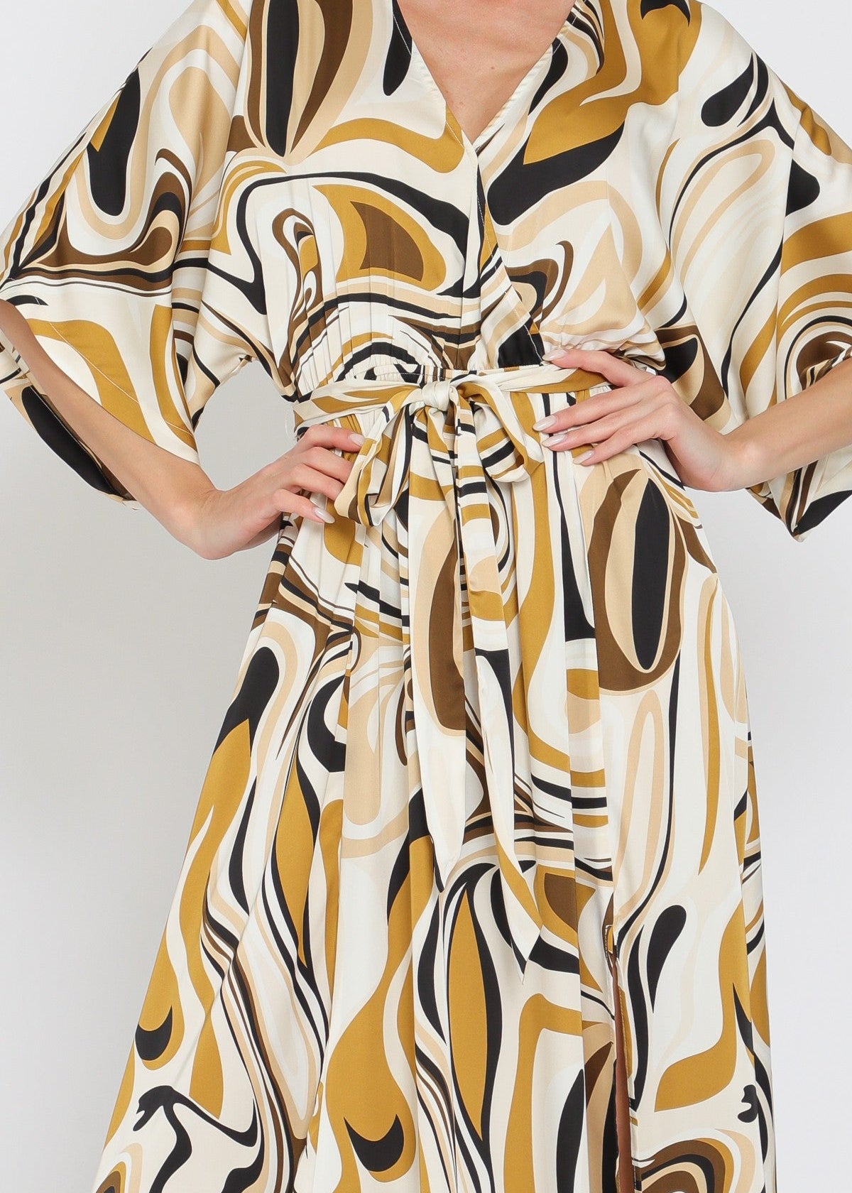 Woman wearing a patterned dress with abstract design on a plain background