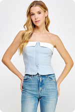 Load image into Gallery viewer, Light chambray contrast color block corset top in suiting twill fabric. This bustier top features contrast fabric detail at bustline, removable adjustable straps, elasticized smocking at back, and button down closure with placket at front. This top can be worn strapless by removing the straps.
