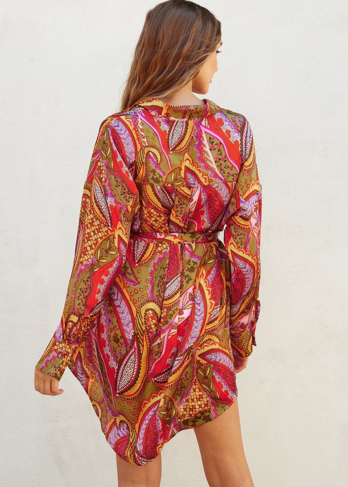 Rio fiesta short shirt dress featuring tropical floral print. Collared. Button down closure. Sash belt.