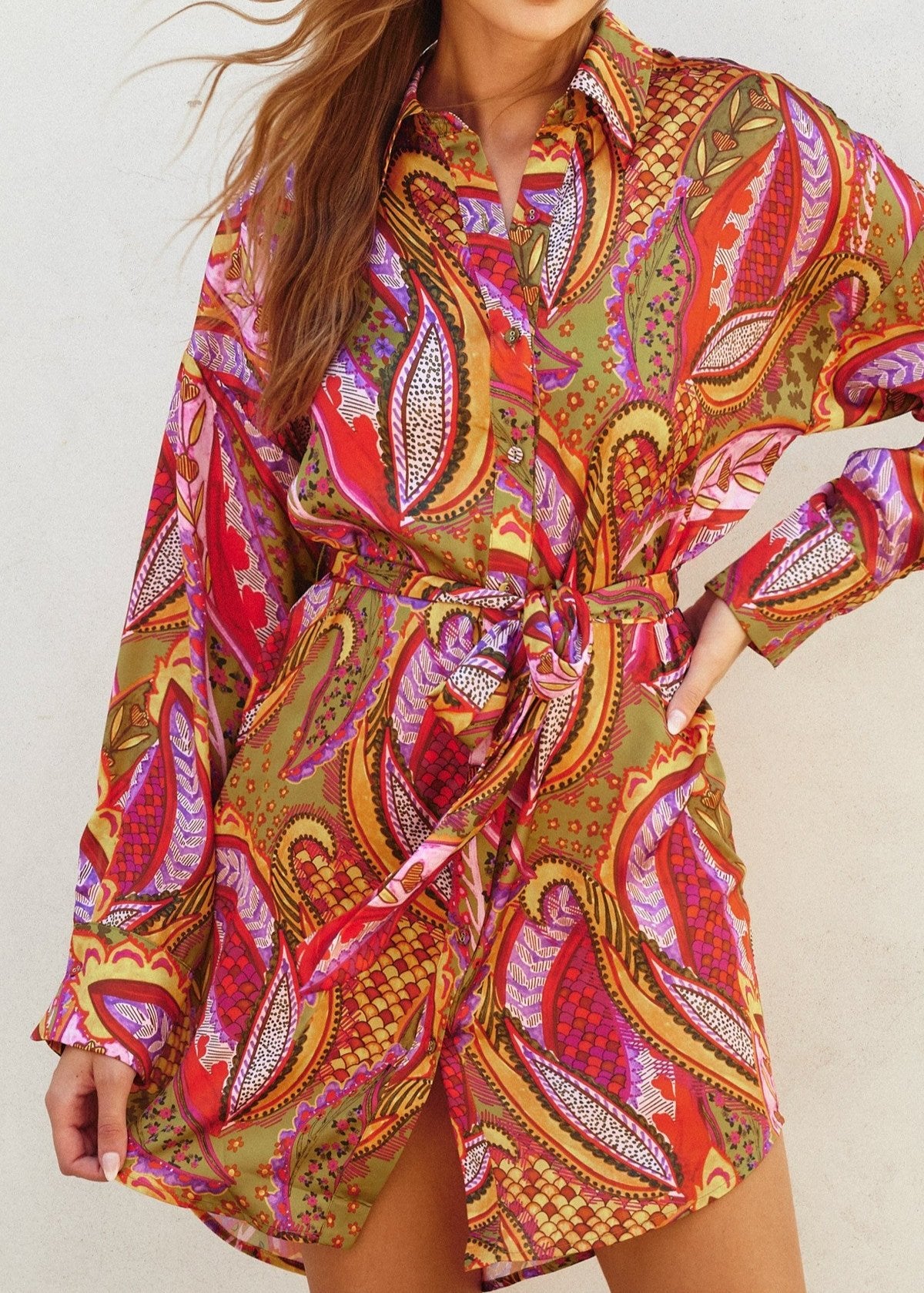 Rio fiesta short shirt dress featuring tropical floral print. Collared. Button down closure. Sash belt.