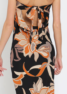 Floral patterned strapless dress with a high slit on a white background