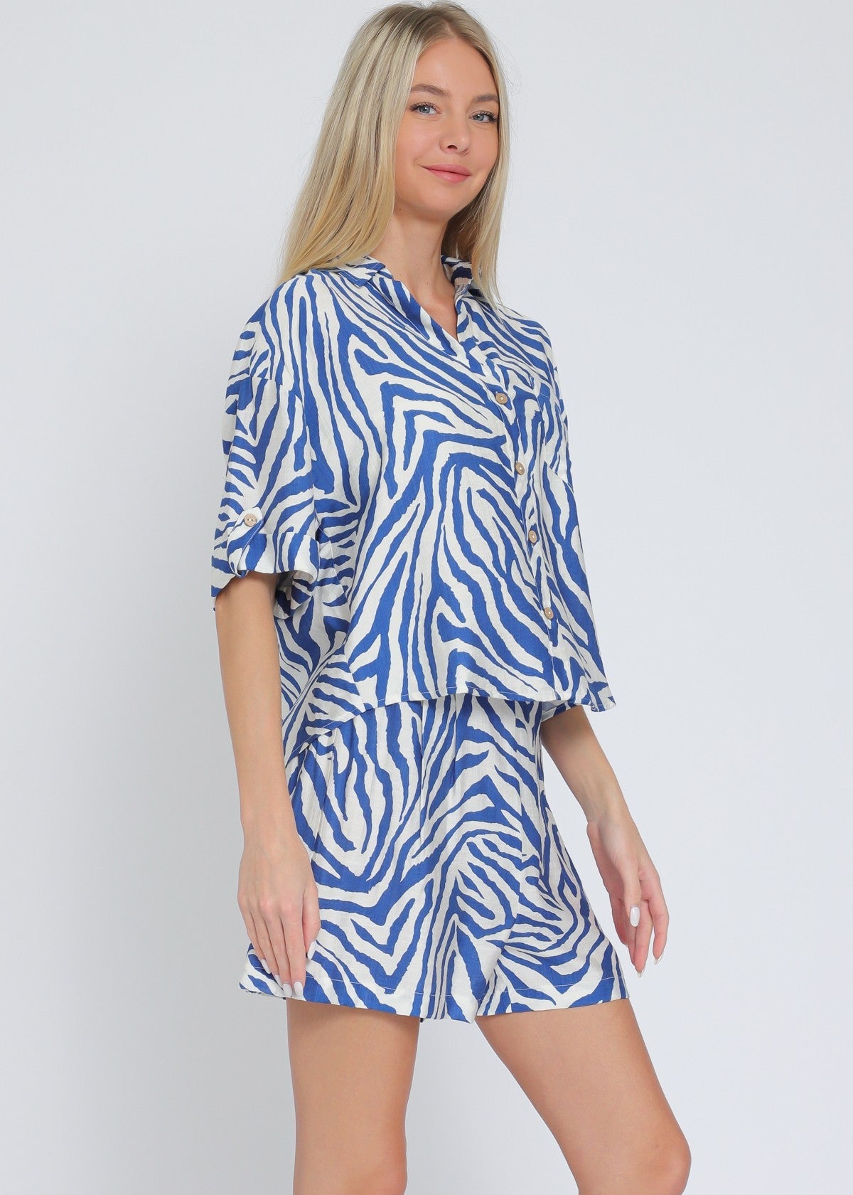 Ivory and blue set featuring short sleeve shirt and elastic waisted shorts.