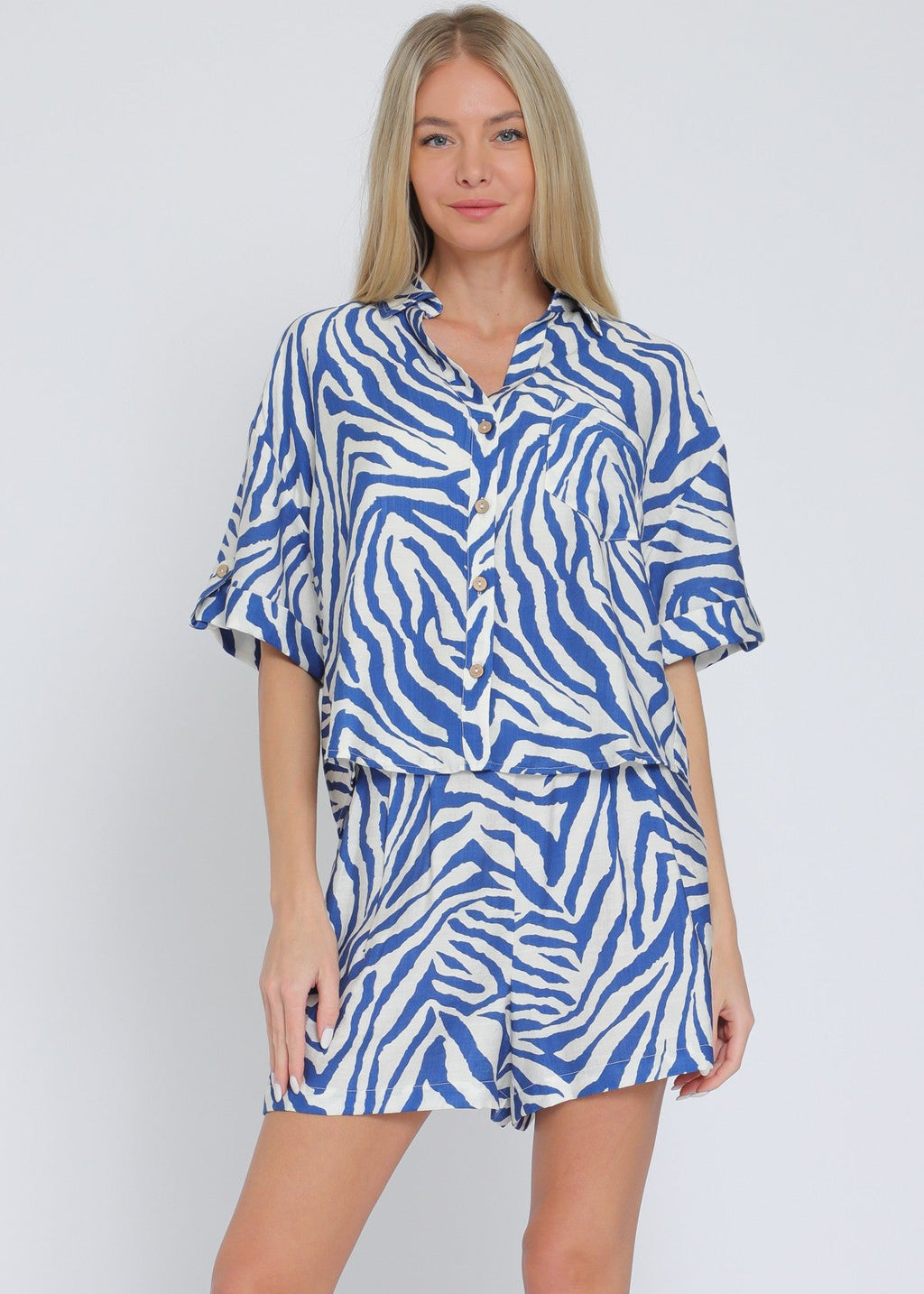 Ivory and blue set featuring short sleeve shirt and elastic waisted shorts.