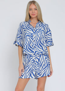 Ivory and blue set featuring short sleeve shirt and elastic waisted shorts.