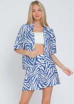 Load image into Gallery viewer, Ivory and blue set featuring short sleeve shirt and elastic waisted shorts.
