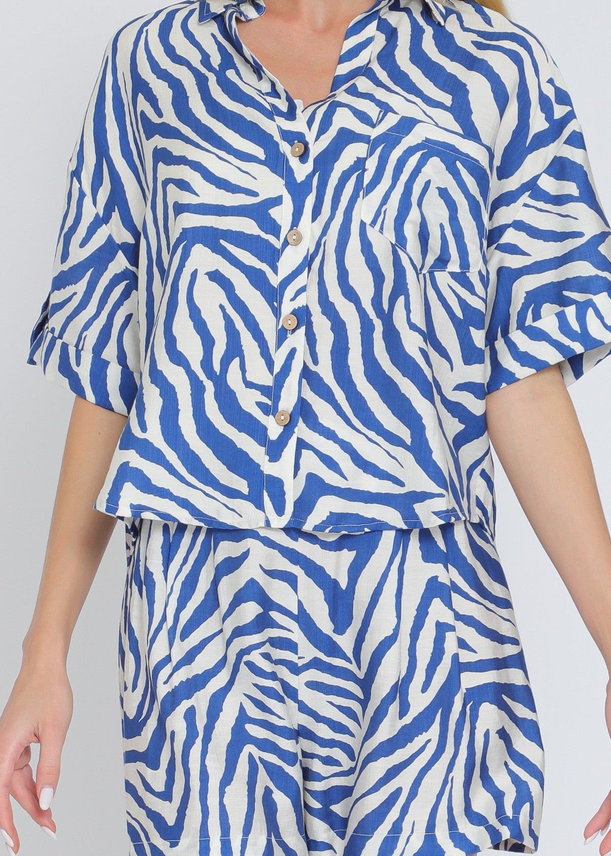 Ivory and blue set featuring short sleeve shirt and elastic waisted shorts.