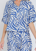 Load image into Gallery viewer, Ivory and blue set featuring short sleeve shirt and elastic waisted shorts.
