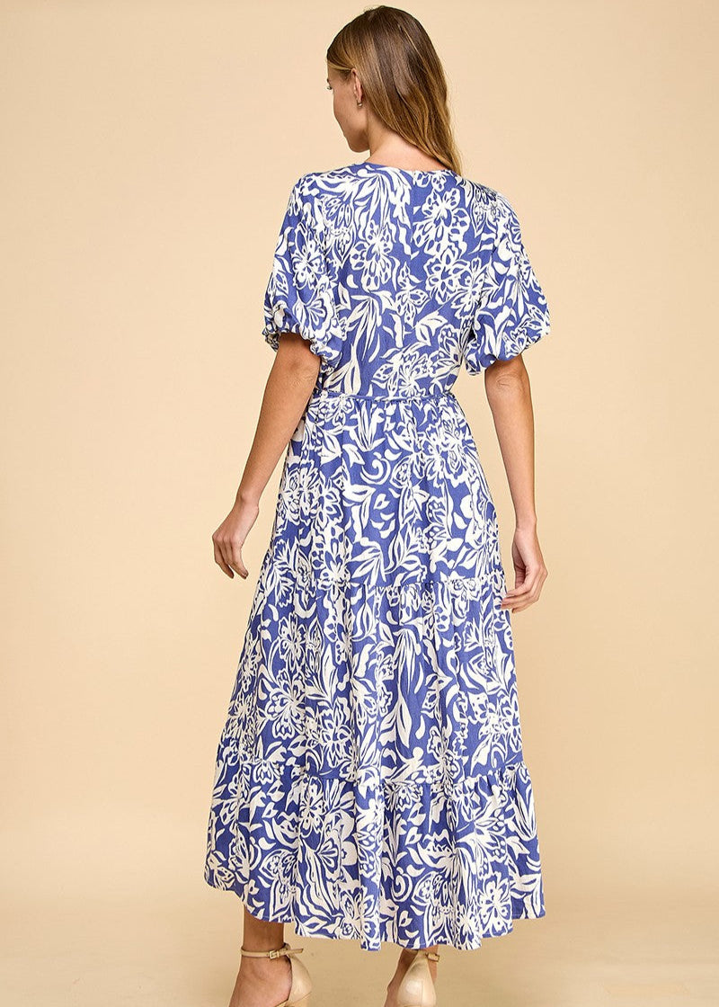 Navy abstract floral print midi dress featuring a V-neck, puffed sleeves, waist tie, and a tiered skirt. Fully lined.
