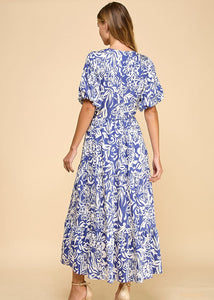 Navy abstract floral print midi dress featuring a V-neck, puffed sleeves, waist tie, and a tiered skirt. Fully lined.