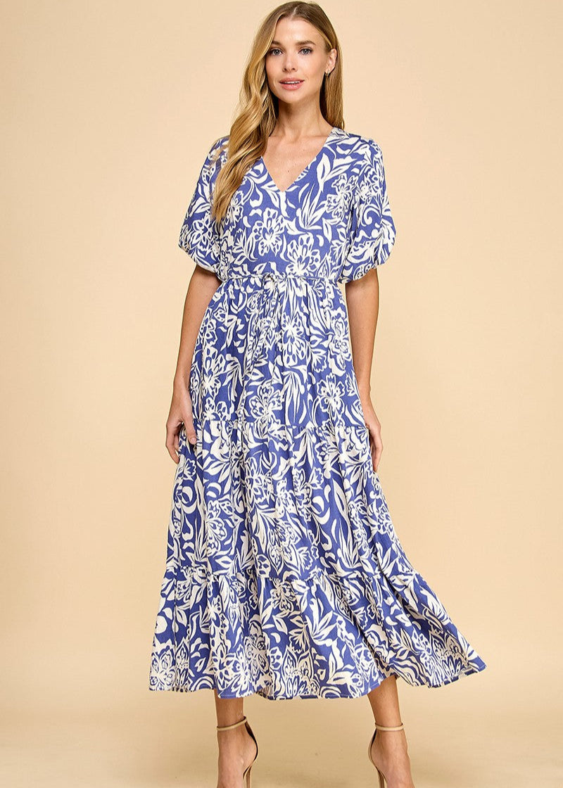 Navy abstract floral print midi dress featuring a V-neck, puffed sleeves, waist tie, and a tiered skirt. Fully lined.