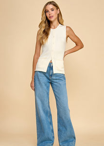 Cream knit button-up vest featuring front pockets for a versatile and stylish look.