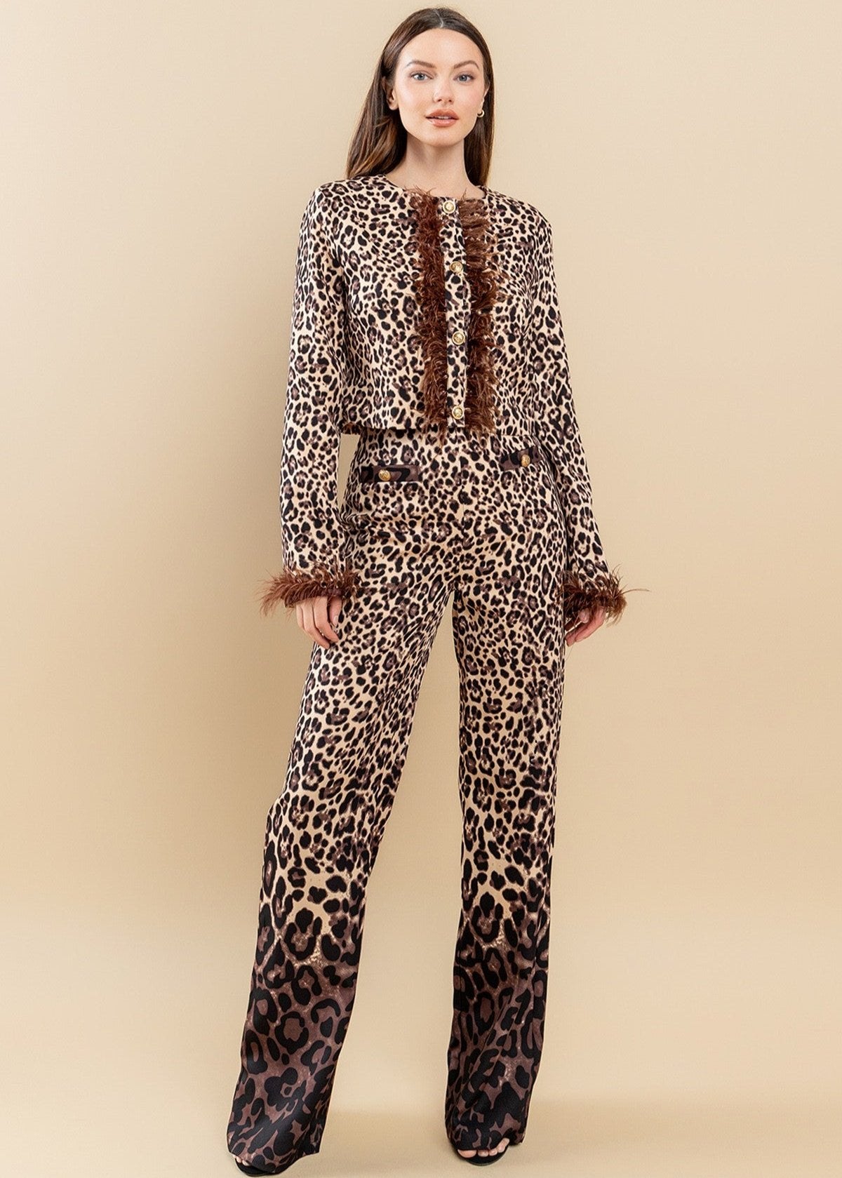 Featuring an all over brown zebra print with ombre design, round neckline, feather trimming as well as a pair of matching pants with a high-rise waist and a wide leg.