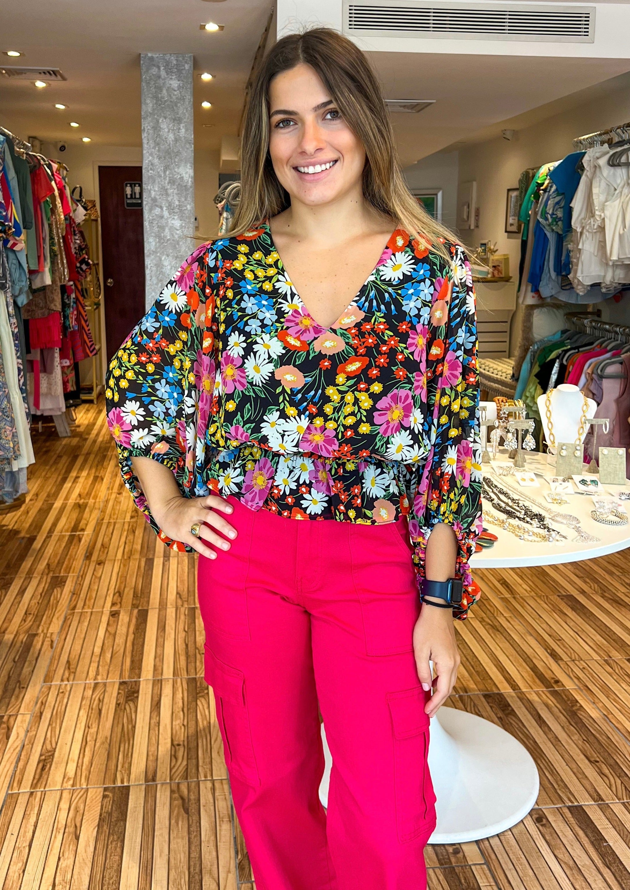 Beautiful and bold, the Lupita Floral print consists of various multicolored flowers against a blackground. The print shapes the evergreen blouse with roomy full sleeves and a shallow V neckline. The bodice maintains a relaxed fit with an elastic waist to create a peplum silhouette. Wear it to work or out to brunch along with black trousers and cute strappy heels.