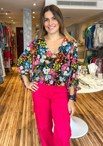 Beautiful and bold, the Lupita Floral print consists of various multicolored flowers against a blackground. The print shapes the evergreen blouse with roomy full sleeves and a shallow V neckline. The bodice maintains a relaxed fit with an elastic waist to create a peplum silhouette. Wear it to work or out to brunch along with black trousers and cute strappy heels.