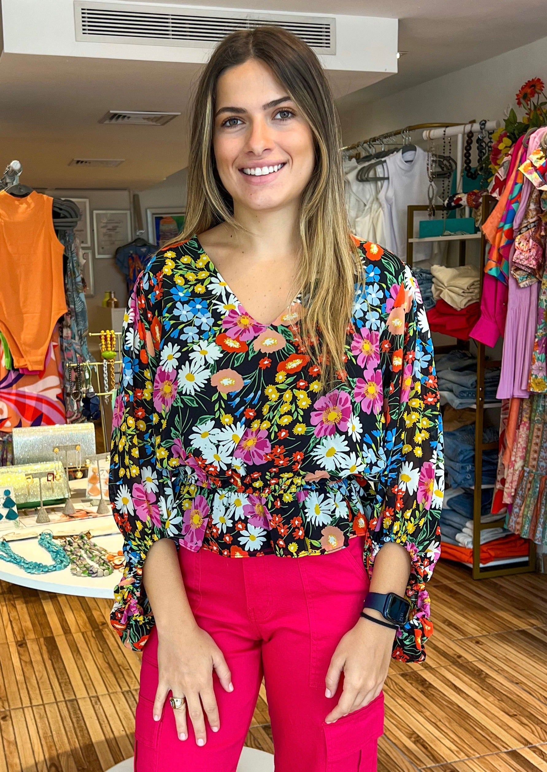 Beautiful and bold, the Lupita Floral print consists of various multicolored flowers against a blackground. The print shapes the evergreen blouse with roomy full sleeves and a shallow V neckline. The bodice maintains a relaxed fit with an elastic waist to create a peplum silhouette. Wear it to work or out to brunch along with black trousers and cute strappy heels.