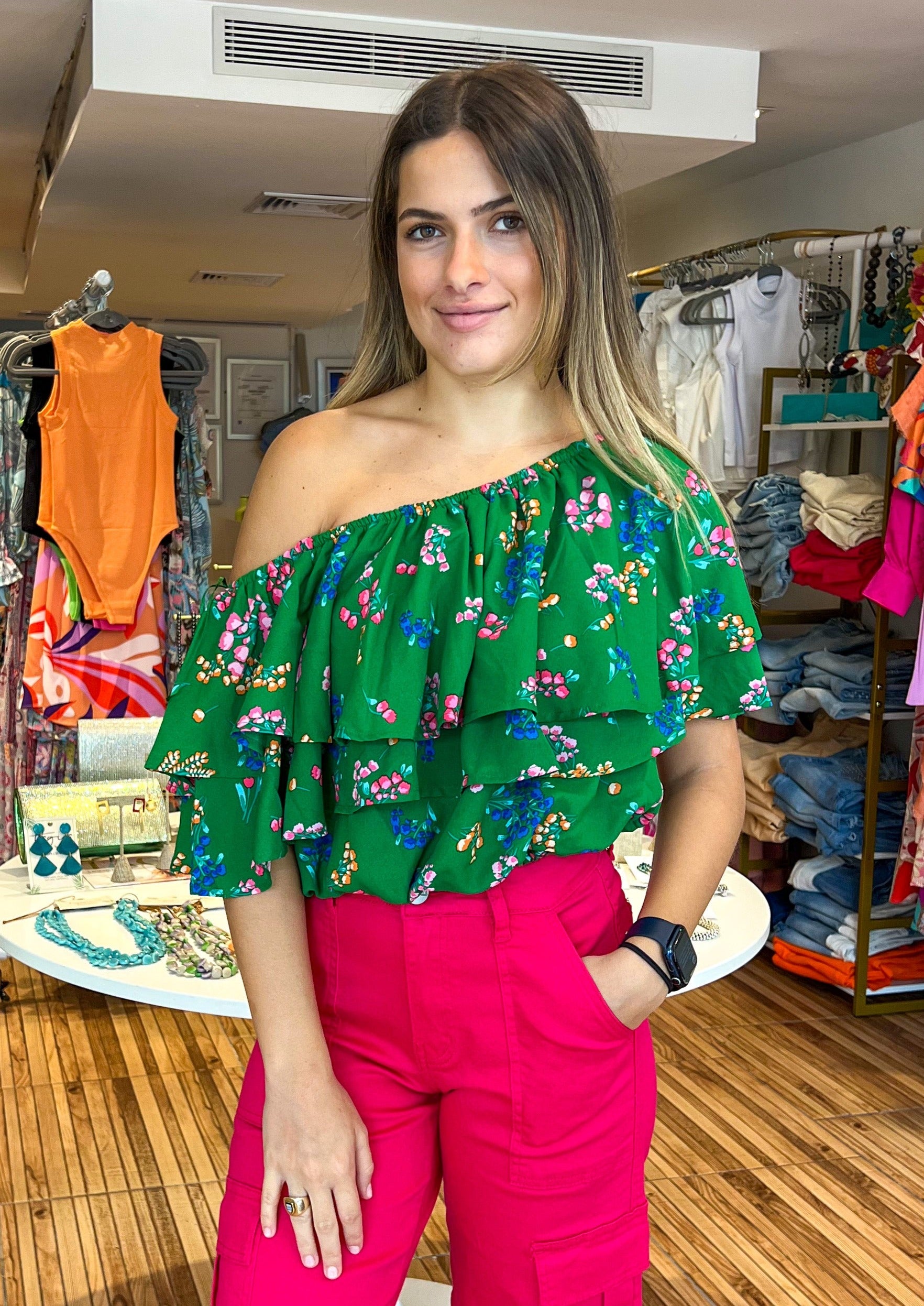 Color your world with multi color floral clusters that make up the Ivana print. It shapes the evergreen, Charmer top. A single shoulder with a double ruffle layer that overlays a voluminous cropped bodice. Style it with trouser shorts and loafers for a completed look.
