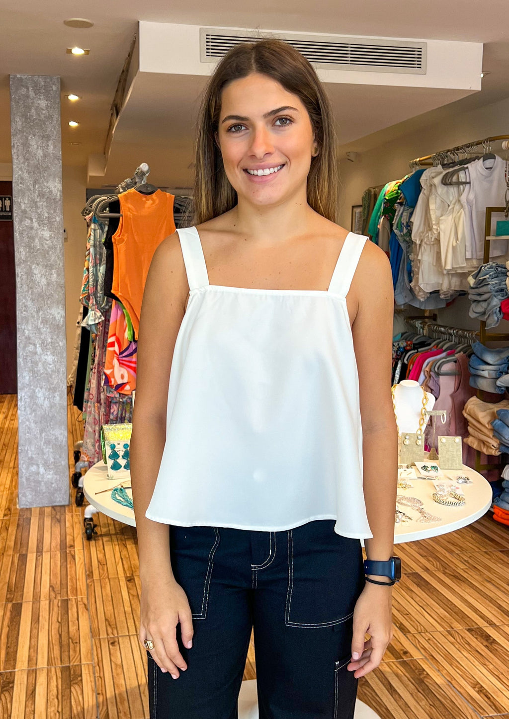 A true classic. This timeless top features a square neck that tops an A line cropped silhouette. Thicker straps have a knotted detail at the back where it meets a scoop backline. Easily wear it with your favorite bottoms and dress up the look with accessories and strappy heels.