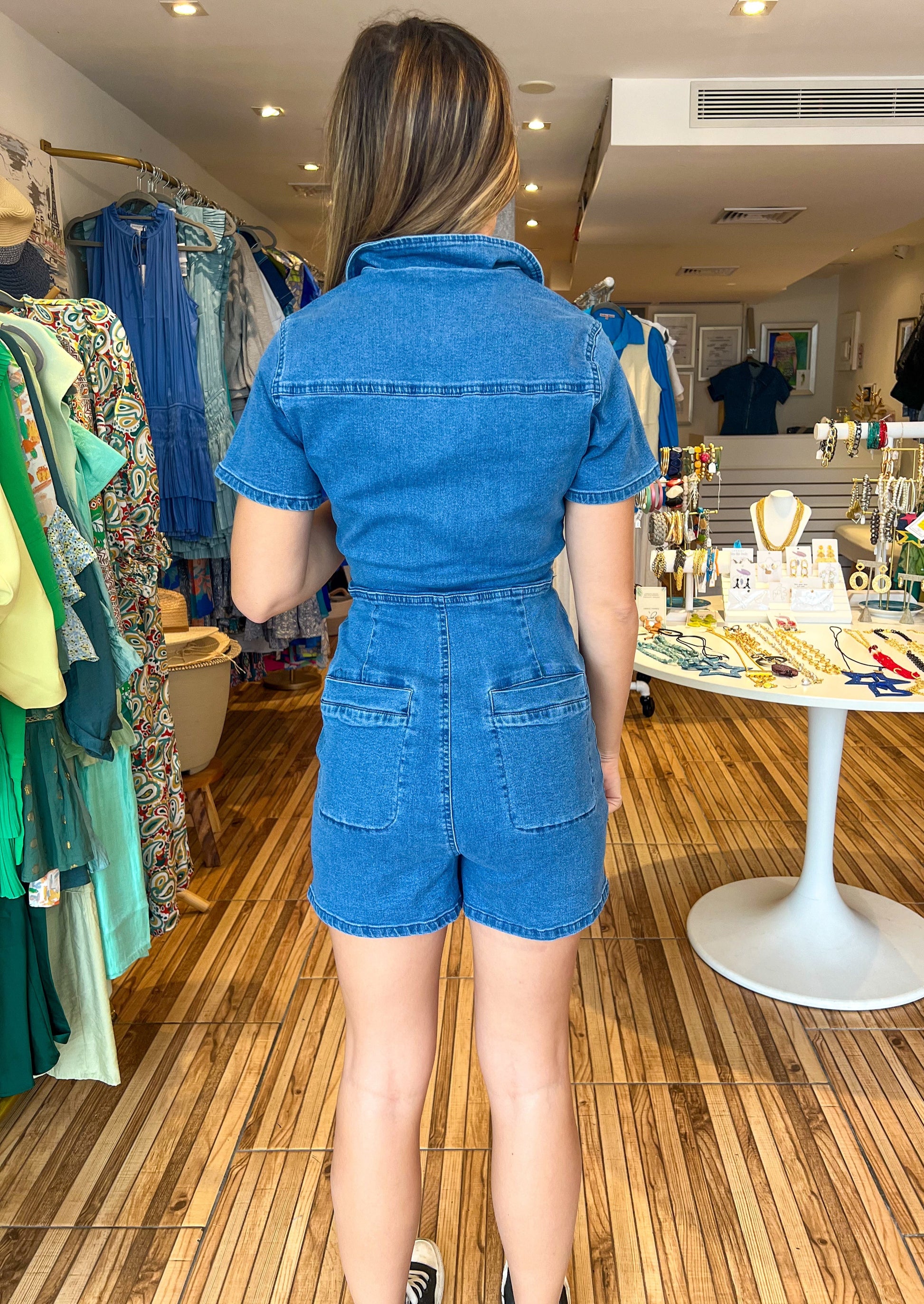 Denim short sleeve denim romper with front top and bottom pockets and back pockets.