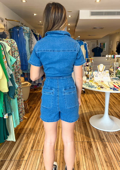 Denim short sleeve denim romper with front top and bottom pockets and back pockets.