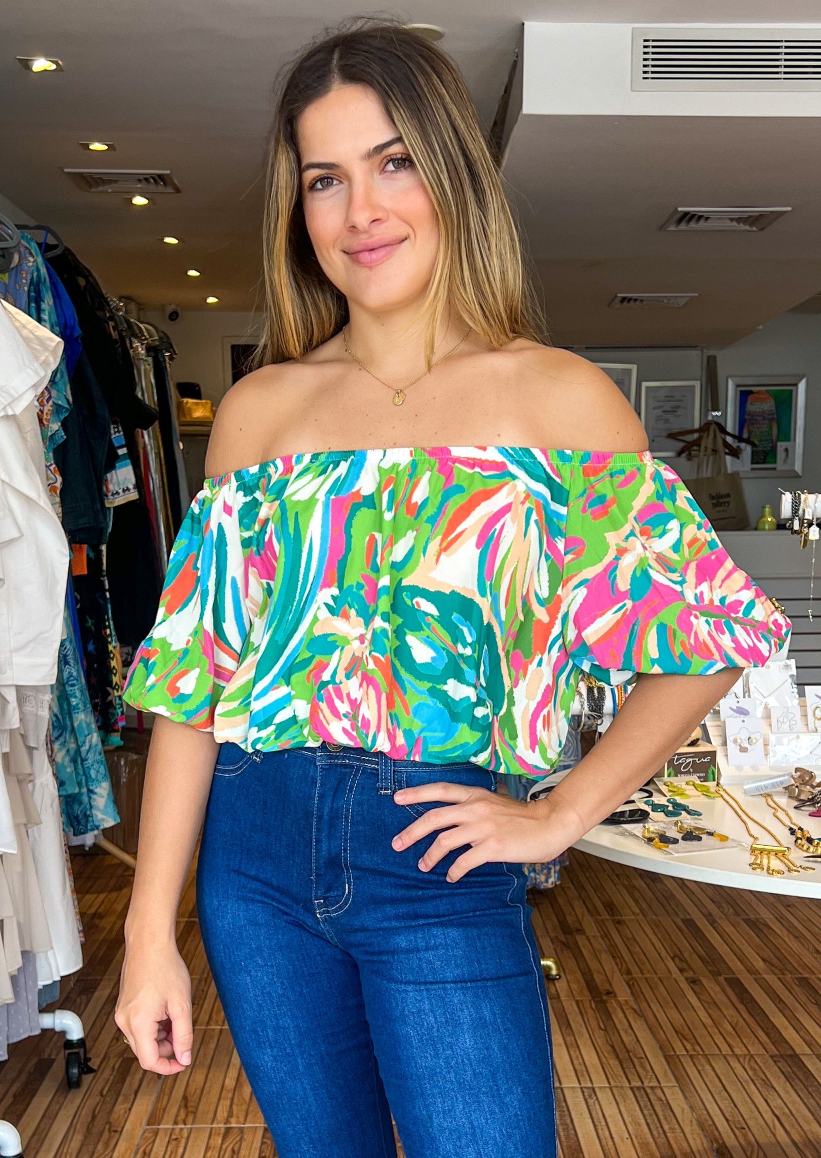 Green and pink printed woven top featuring on/off shoulder neckline with elasticized waist.