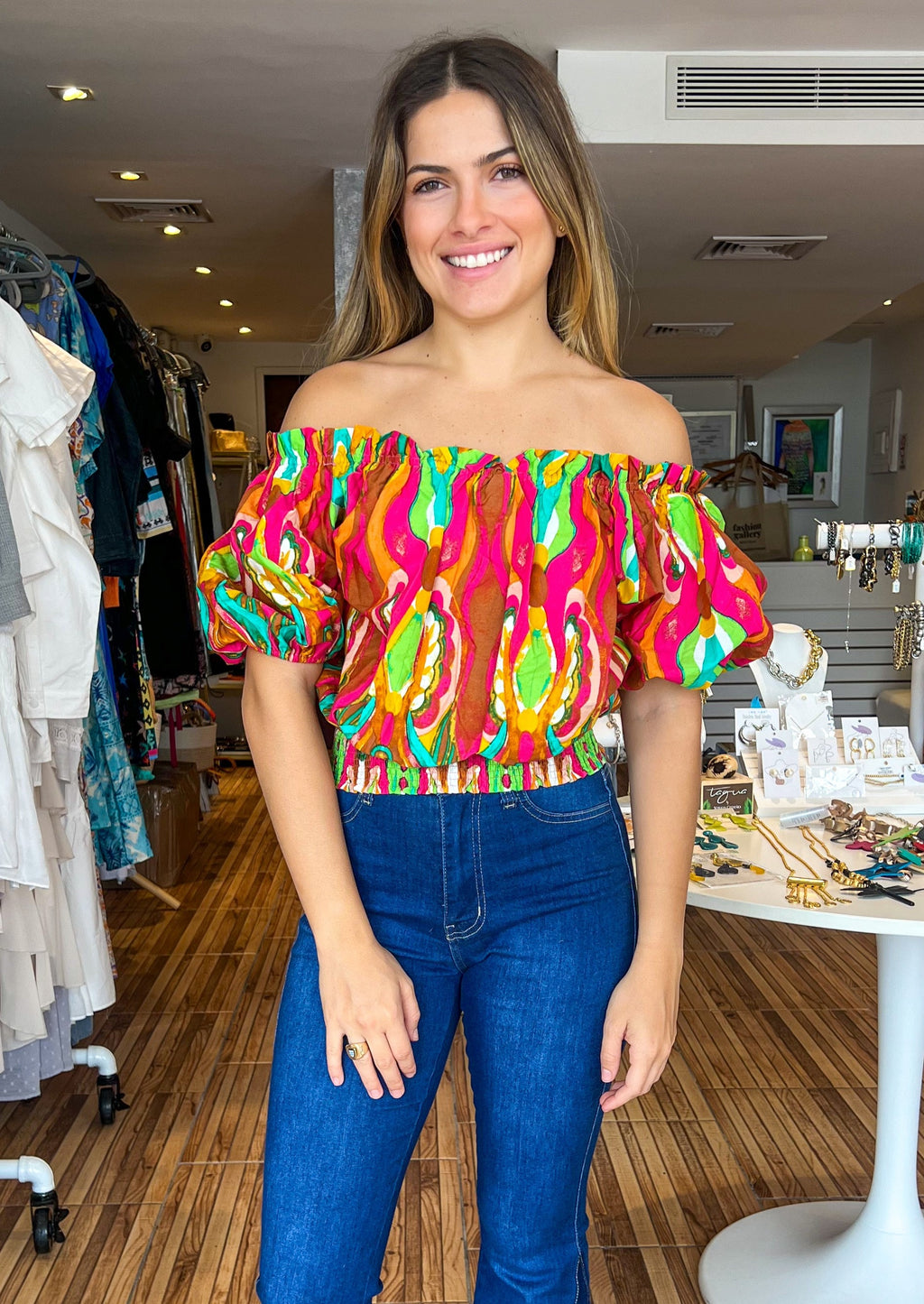 Fuchsia lime printed woven top featuring off shoulder neckline with riffled edge, short puff sleeve and smocked waist band.