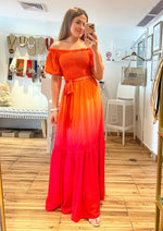 Load image into Gallery viewer, Orange fuchsia printed woven maxi dress featuring off shoulder neckline with ruffled edge, smocked bodice with self sash tie and ruffled hemline.
