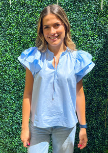 Light blue short flutter sleeve v-neck blouse.