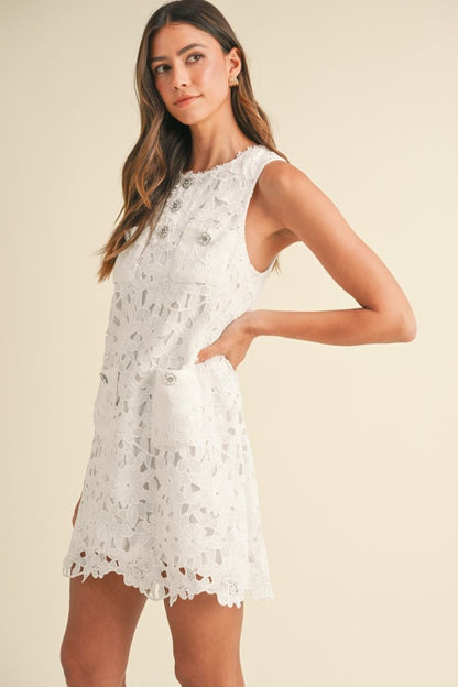 Off White sleeveless lace crochet mini shift dress with rhinestone embellished buttons detail. Lining.