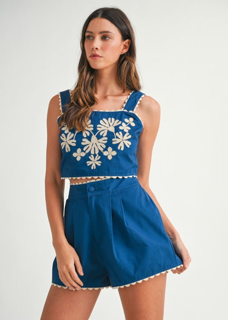 Solid sleeveless floral embroidered detail crop top with back button closure and matching shorts with front button set. Lining.