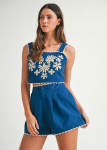 Solid sleeveless floral embroidered detail crop top with back button closure and matching shorts with front button set. Lining.