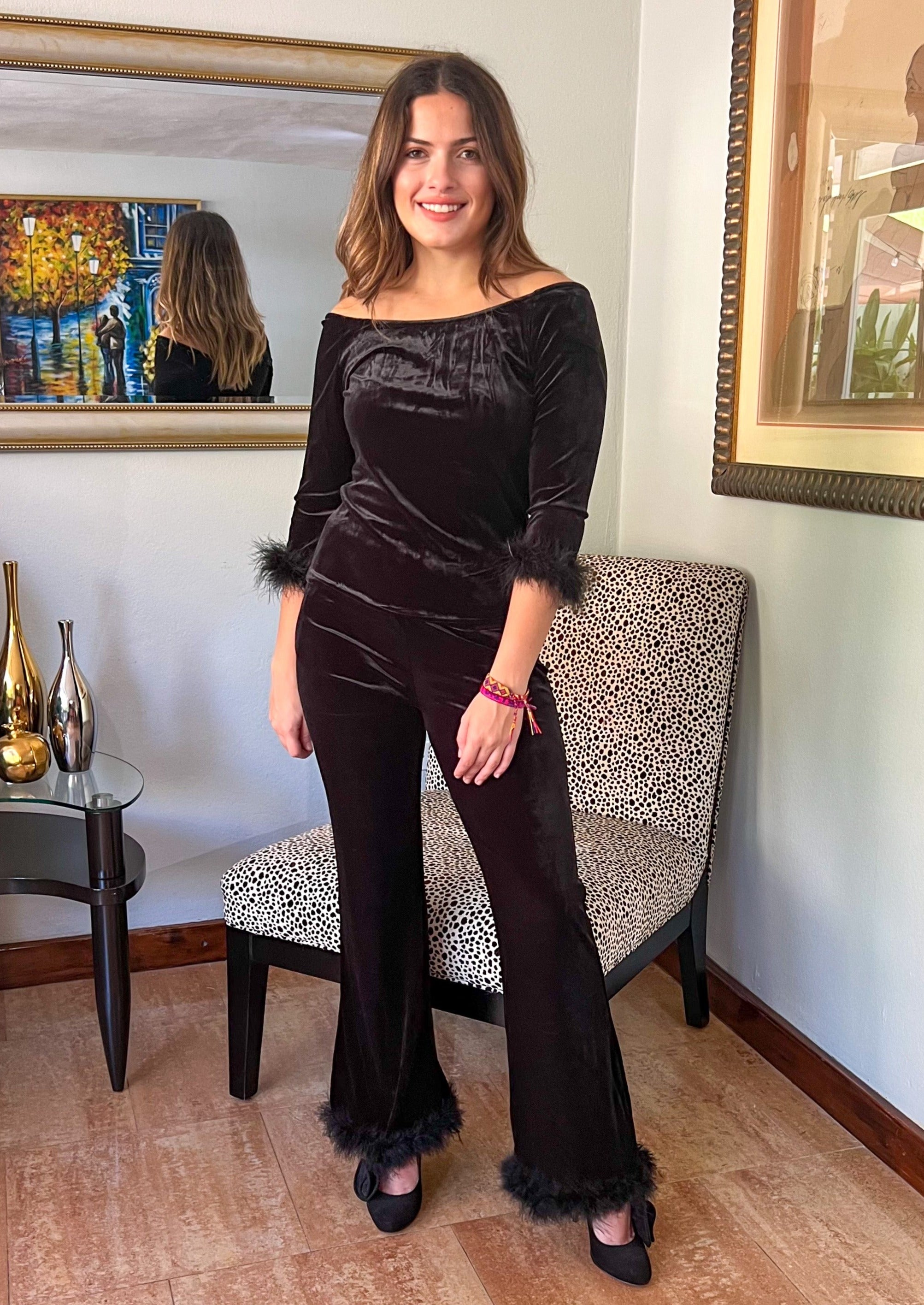 Two piece black suede set with feather details. Feather trim around the 3/4 length sleeve and around the bottom of the pants.